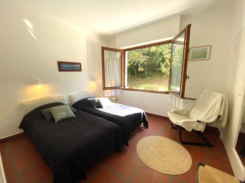 ein Schlafzimmer mit einem Bett, einem Stuhl und einem Fenster in der Unterkunft PINSONS maison familiale proche plage in Pyla-sur-Mer