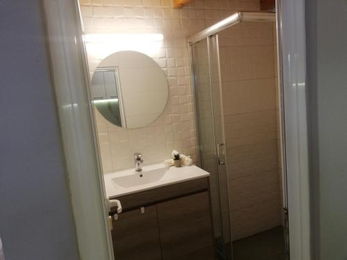 a bathroom with a sink and a mirror and a shower at SPYROS STONE house in Preveza