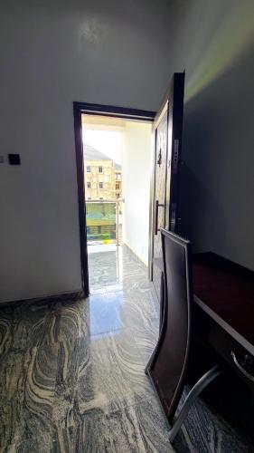 a room with a chair and an open door at The Marble Hotel and Apartments in Uyo