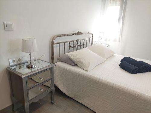 a bedroom with a bed and a night stand with a lamp at El Rincón de San Fermín in Zizur Mayor