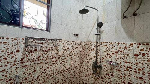 a shower in a tiled bathroom with a window at Skill forest lodge in Arusha