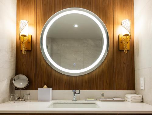 a bathroom with a sink and a large mirror at Hôtel-Musée Premières Nations in Wendake
