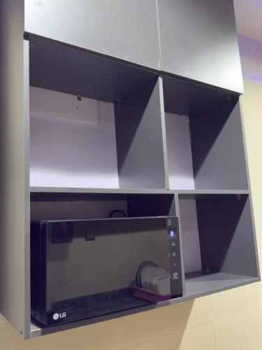 a microwave oven with its door open on a shelf at Lagos Luxury Duplex in Iju