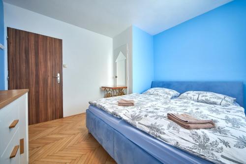 a bedroom with a bed with a blue and white comforter at Penzion Zajíček in Zaječí