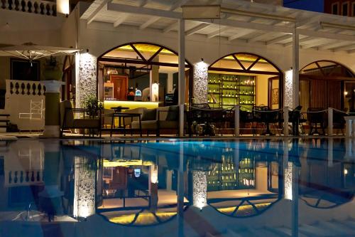 a pool at a hotel with a bar in the background at Fedra Mare in Agios Stefanos