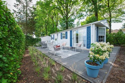 a blue house with chairs and a patio at 87, gelegen in het rustige & bosrijke Oisterwijk! in Oisterwijk