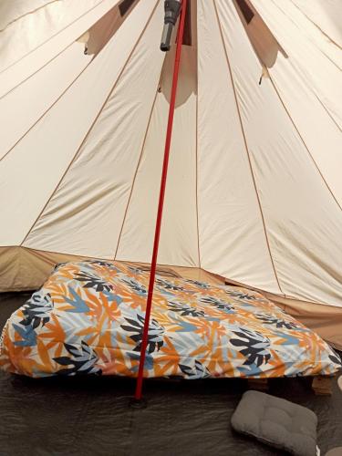 une tente avec une couverture devant dans l'établissement tente nature, à Plouray