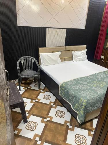 a bedroom with a bed and a chair on a floor at Govind dham in Vrindāvan