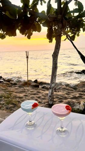 two wine glasses sitting on a table next to the ocean at Azul profundo Rooftop in Turbo