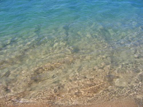 a close up of the clear water on the beach at Moinhos das Marés in Fuzeta