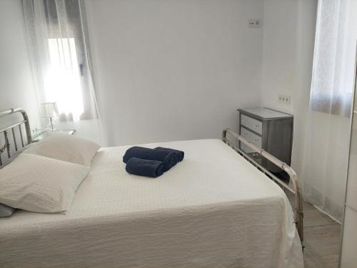 a white bed with a blue pillow on top of it at El Rincón de San Fermín in Zizur Mayor