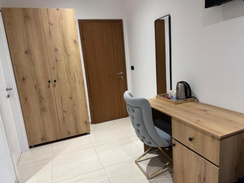 a wooden desk with a blue chair in a room at Hotel Majestic in Struga