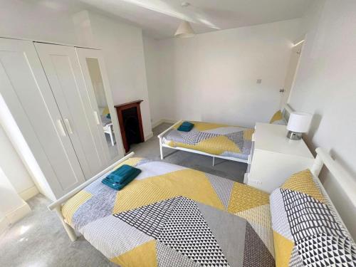 a small room with two beds and a mirror at 4-Bedroom House - Thornton Heath in Thornton Heath
