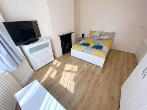 a bedroom with a bed and a flat screen tv at 4-Bedroom House - Thornton Heath in Thornton Heath