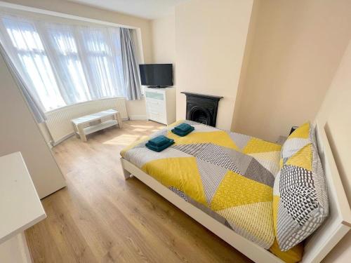 a bedroom with a bed and a fireplace and a television at 4-Bedroom House - Thornton Heath in Thornton Heath