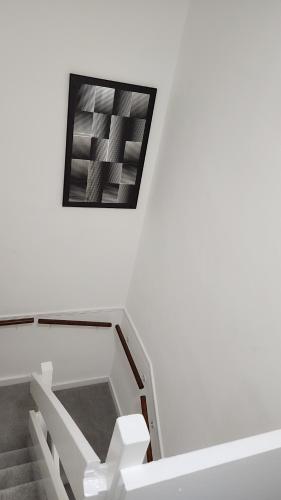 a stair case with a picture on the wall at Luxurious ensuite rooms in Basildon