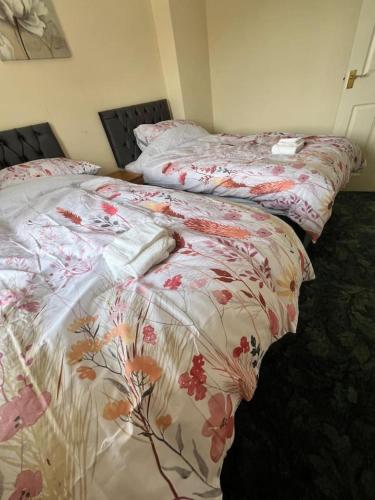 two beds sitting next to each other in a bedroom at Canal Way- Cozy 3-Bed House in Ilminster