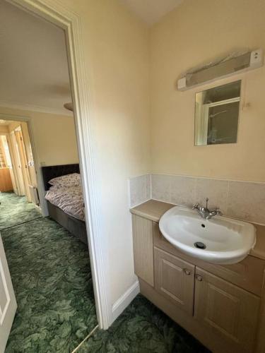 a bathroom with a sink and a bed at Canal Way- Cozy 3-Bed House in Ilminster