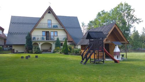 una casa con parque infantil frente a una casa en Willa Majerczyk, en Zakopane