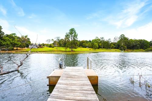 a wooden dock in the middle of a lake at Oleander Escape Lake Front Retreat in Yungaburra