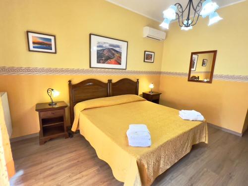 a bedroom with a bed in a yellow room at Ai Tre Parchi Bed And Bike in Randazzo