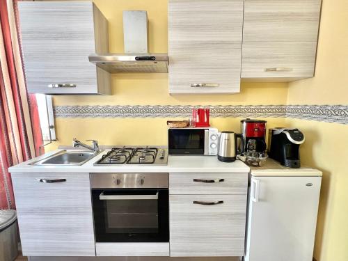 a small kitchen with a stove and a sink at Ai Tre Parchi Bed And Bike in Randazzo