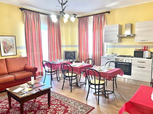 a living room with tables and chairs and a kitchen at Ai Tre Parchi Bed And Bike in Randazzo