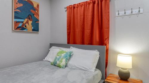 a bedroom with a bed with a lamp and a window at Cozy and Private Studio w Outdoor Deck in St Petersburg