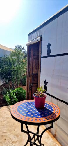a table with a potted plant on top of it at Ez-zine Glam in El Aadamna