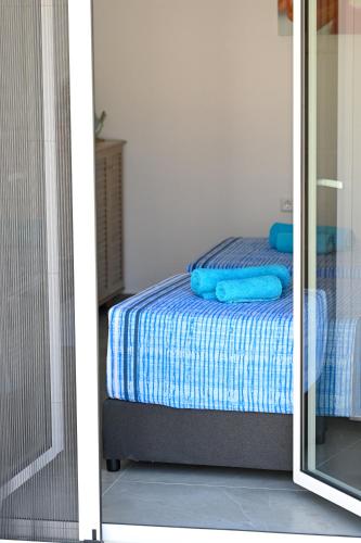 a bedroom with a bed with blue sheets and a mirror at Anchor Villa in Troulos