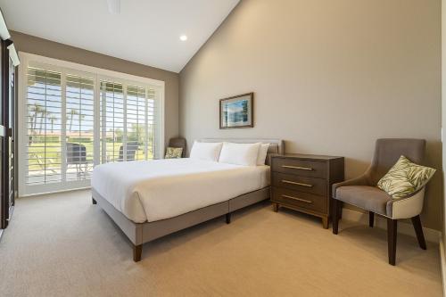 a bedroom with a bed and a chair and a window at Chic Palm Desert Gem - Relax, Swim, Repeat in Palm Desert