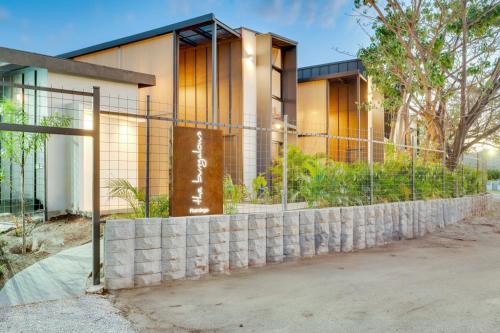 a house with a retaining wall and a fence at The Bungalows Flamingo - 10 Unit Boutique Hotel in Playa Flamingo