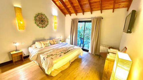 a bedroom with a bed and a large window at Arcano Casa Montaña in Villa La Angostura