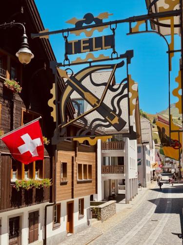 a building with a flag on the side of it at Taurus Tell Gasthaus Andermatt in Andermatt