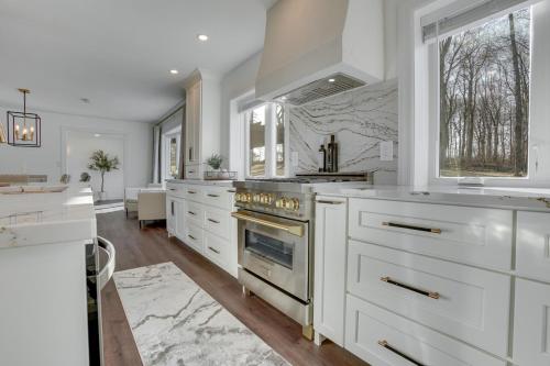 a kitchen with white cabinets and a stove at Zook Manor with Hot tub Firepit and Game Room in Atglen