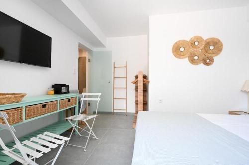 a bedroom with a bed and a tv and chairs at Anchor Villa in Troulos