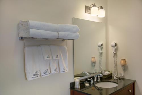 ein Badezimmer mit Waschbecken, Spiegel und Handtüchern in der Unterkunft Lanes Riverhouse Inn & Cottages in Montague