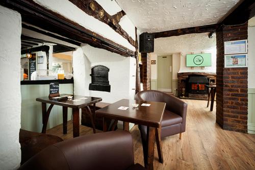 a dining room with two tables and a fireplace at King William in Luton