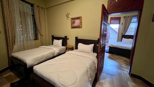 a room with two beds in a room at Skill forest lodge in Arusha