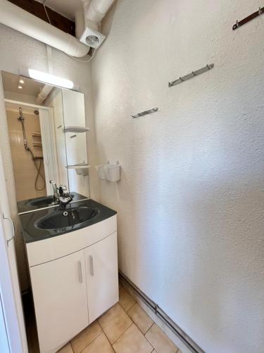 une petite salle de bain avec un lavabo et un miroir dans l'établissement Maison T3 cabine 4 couchages, terrasse cloturée, résidence Sun village avec piscine commune, 300m de la plage à PORTIRAGNES -LRSUNP5, à Portiragnes