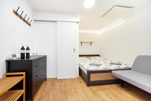 a small bedroom with a bed and a couch at Penzion Zajíček in Zaječí