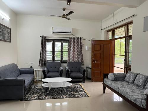 a living room with couches and a coffee table at Naidu Nivasam in Secunderabad