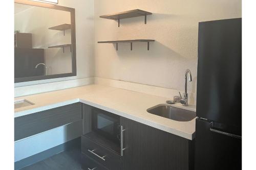 a kitchen with a sink and a mirror at Studio 6 Lake Jackson, TX in Lake Jackson