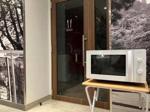 a microwave sitting on a table in front of a door at Smile Hotel Hiroshima in Hiroshima