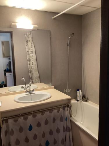 une salle de bain avec un lavabo, un miroir et une baignoire dans l'établissement Beau studio, à Nîmes