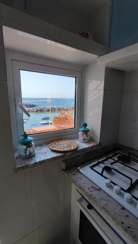 a kitchen with a view of the ocean from a window at La casa di Nonna Rosa in Procida