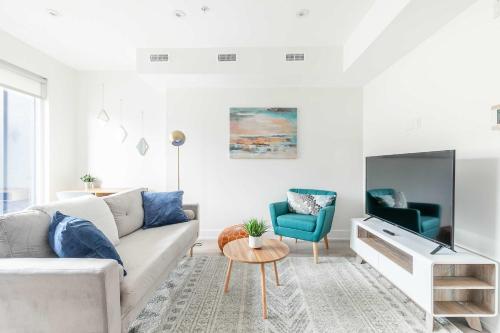 a living room with a white couch and a blue chair at Beautifully Furnished 3BR Apartment Close to High Park Neatest Intersection Lane N Bloor E Indian Rd in Toronto