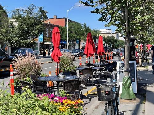 a group of tables and chairs with red umbrellas at Beautifully Furnished 3BR Apartment Close to High Park Neatest Intersection Lane N Bloor E Indian Rd in Toronto