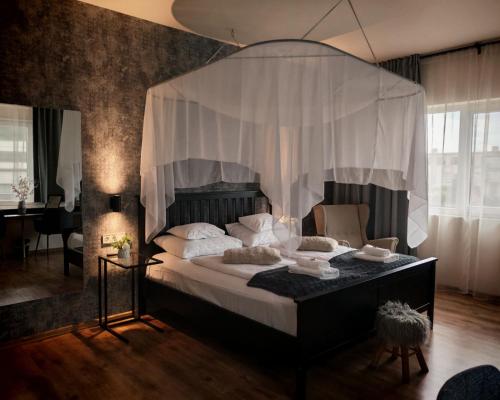 a bedroom with a large bed with a canopy at Boutique Hotel & Event Center in Budapest