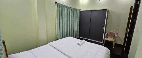 a small bedroom with two beds and a window at Home Inn in Mysore